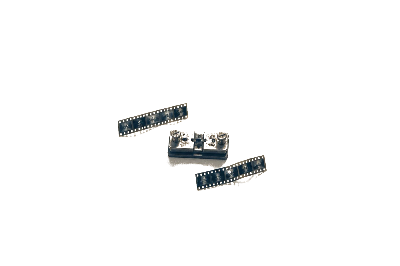 A film splicing block and two short lengths of film on a cutting bench, seen from above